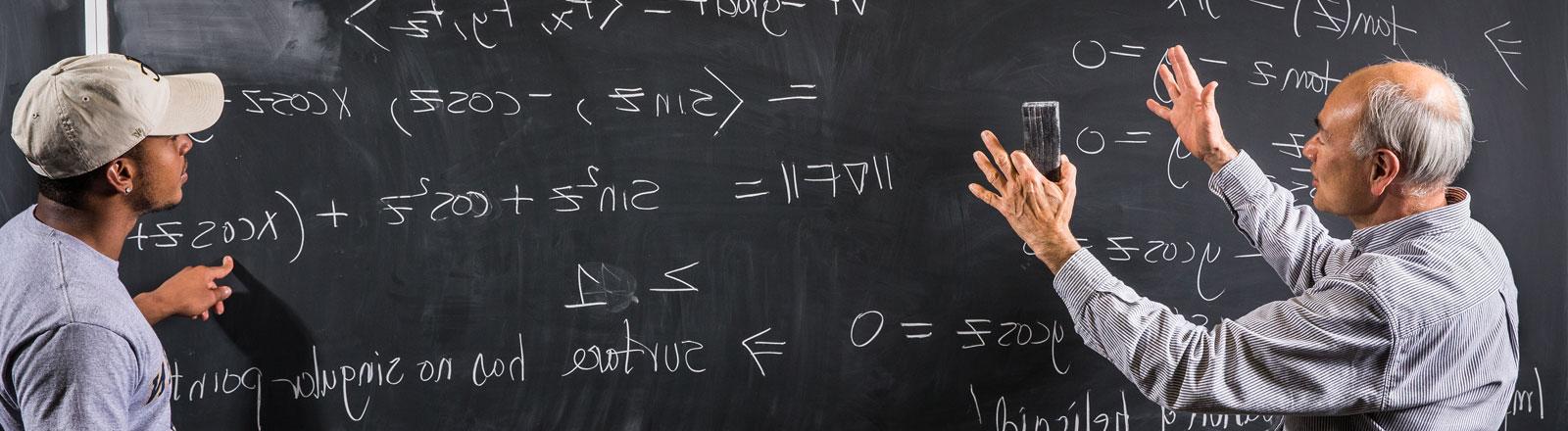 教师和学生在黑板上解释数学概念